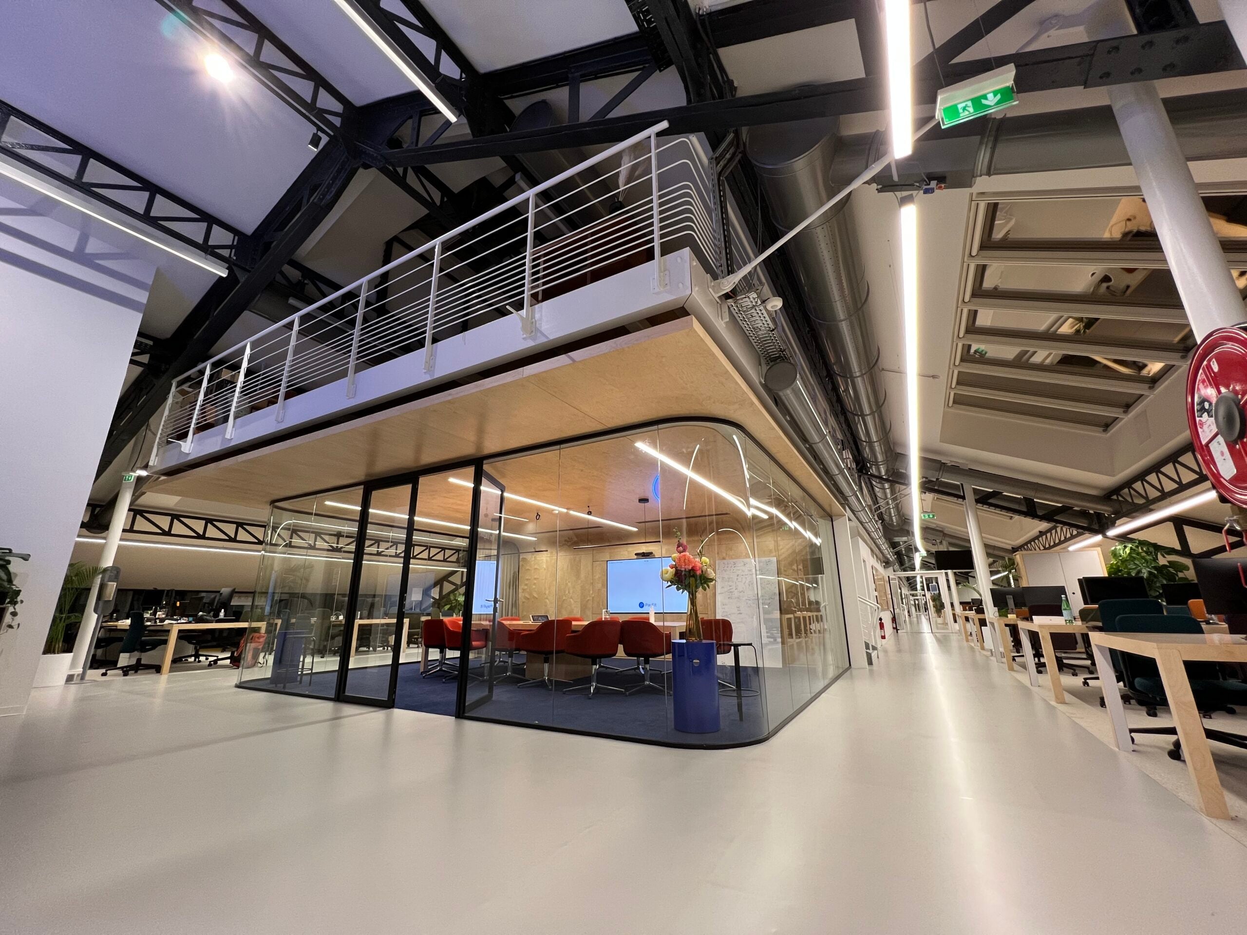 Bureaux d'une startup avec open space, réseau et salle de réunion vitrée