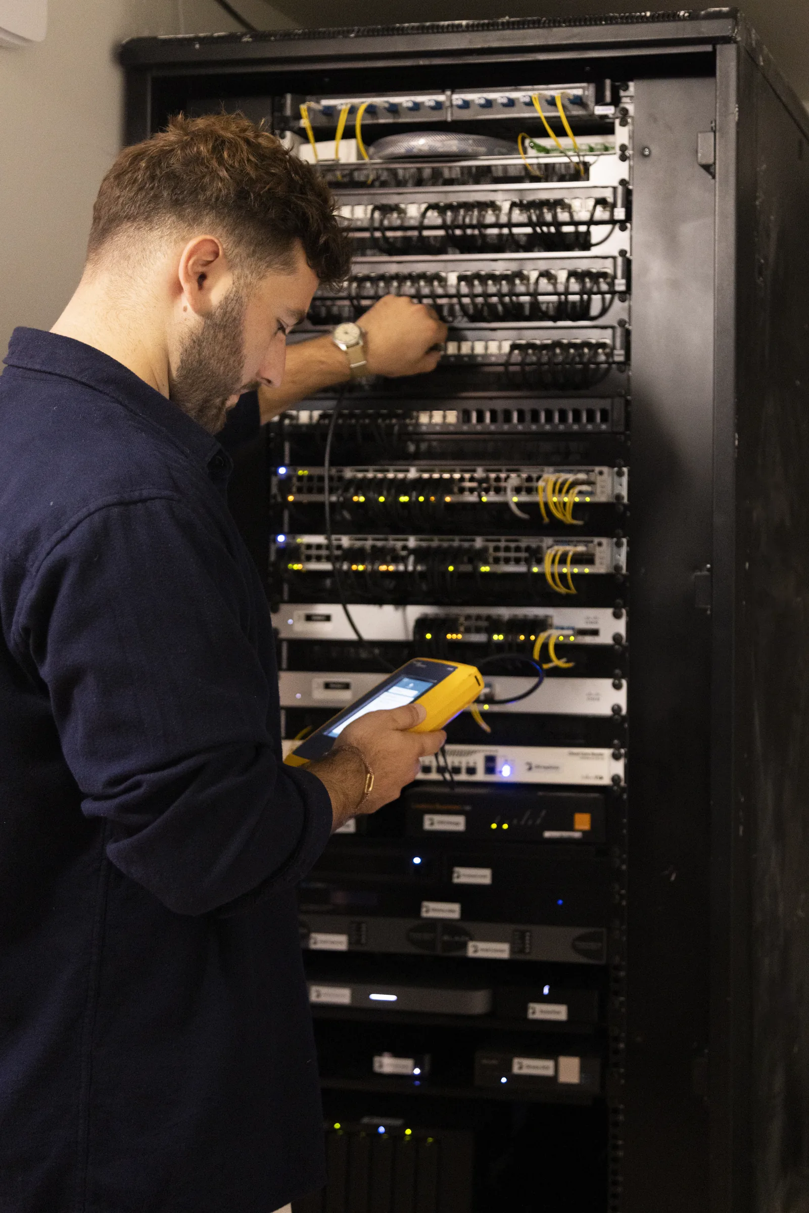 Technicien travaillant dans la baie réseau des bureaux BoucheCousue