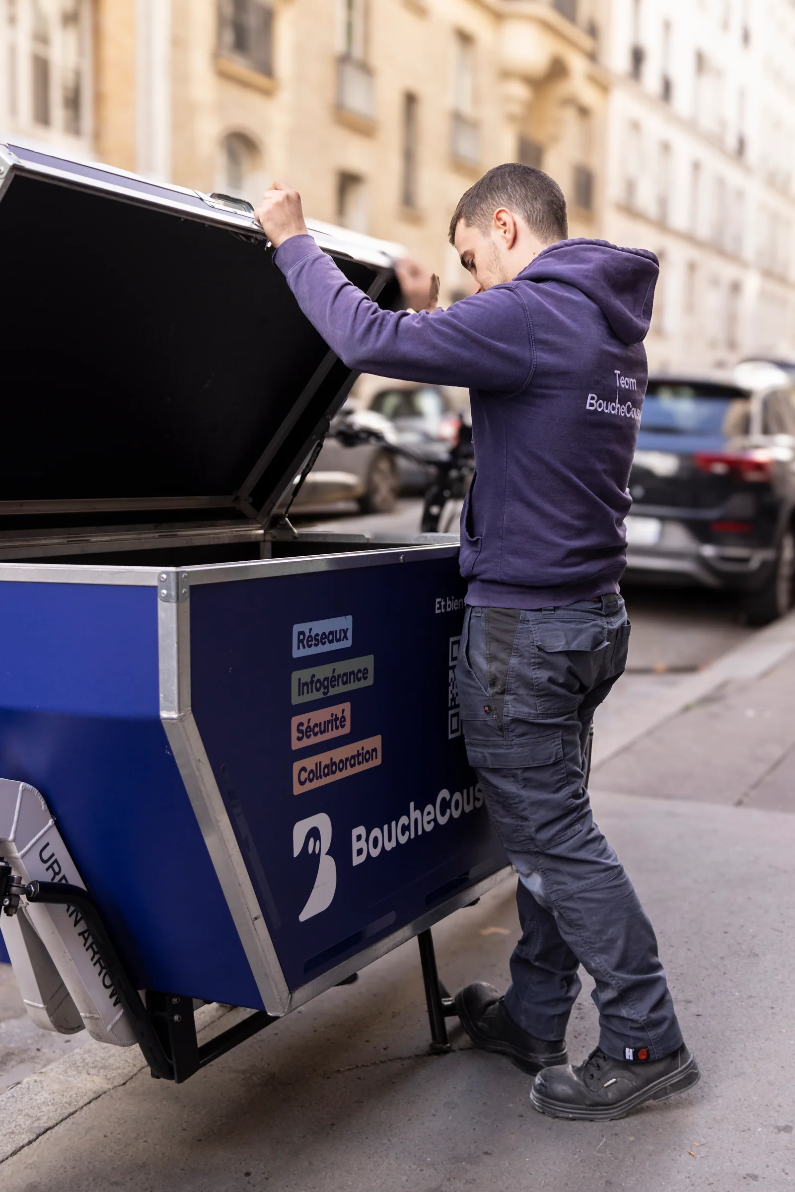 Technicien BoucheCousue ouvrant le coffre d'un vélo cargo d'intervention