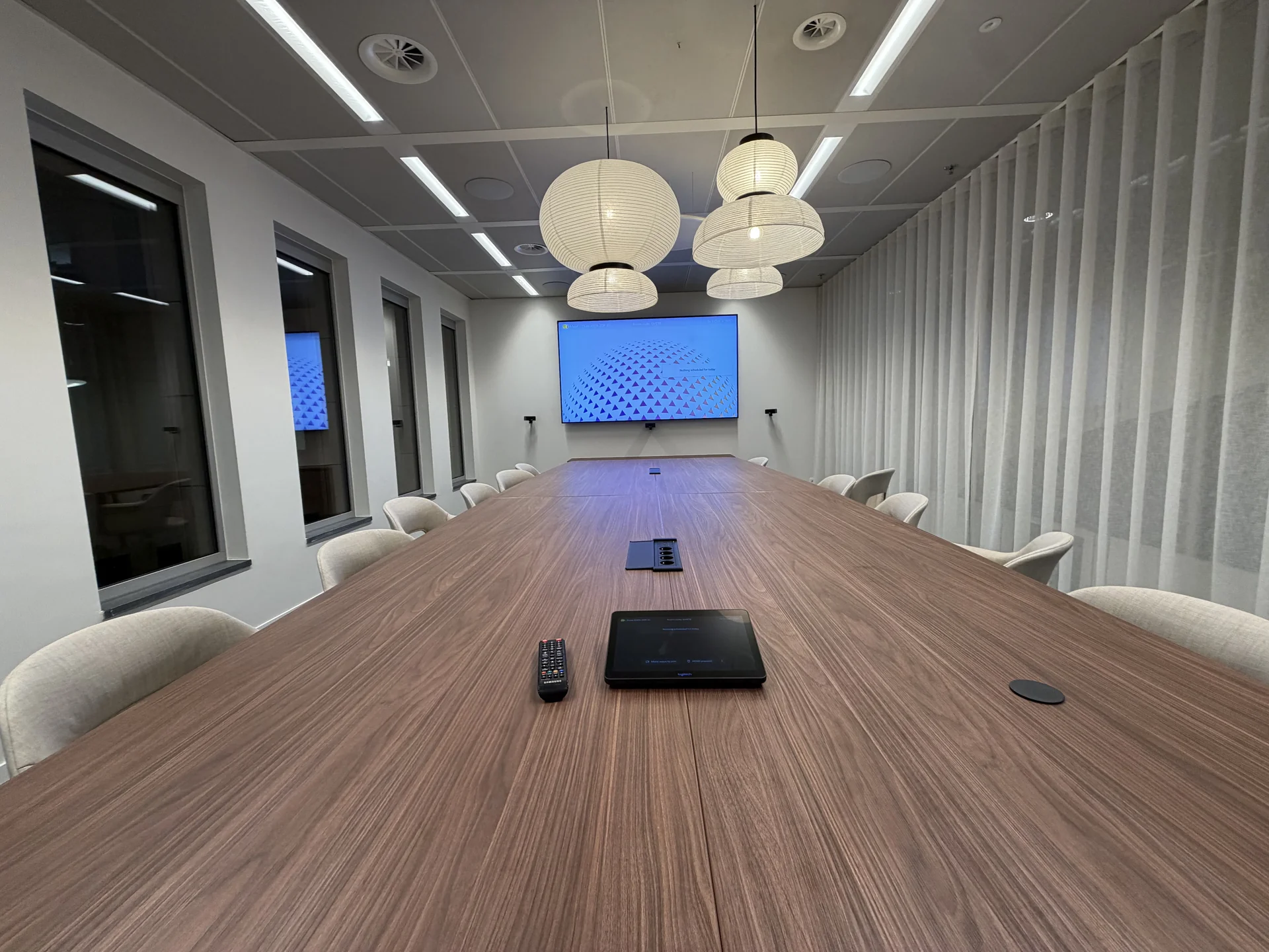 Boardroom Silverfin avec grande table, écran mural et commande Logitech